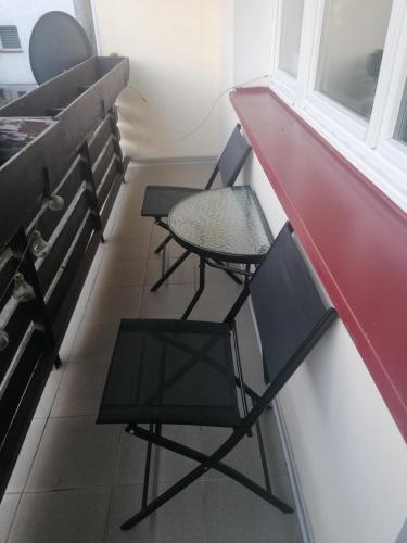 two chairs and a table in a room with a red counter at Nocleg przy Ratuszu in Pieniężno