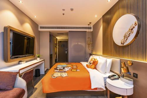 a hotel room with a bed and a tv at Atour X Hotel West Nanjing Road in Shanghai