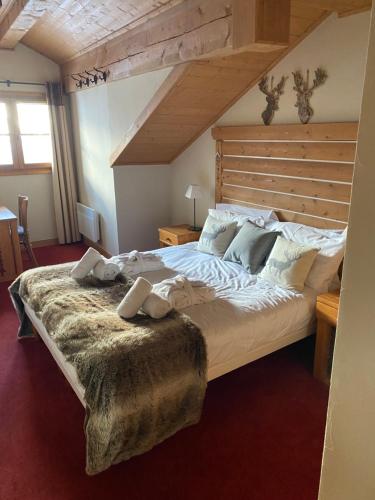 une chambre avec un grand lit avec une tête de lit en bois dans l'établissement Stunning 3 bed duplex in the heart of Arc 1950 village - sleeps 8, à Bourg-Saint-Maurice