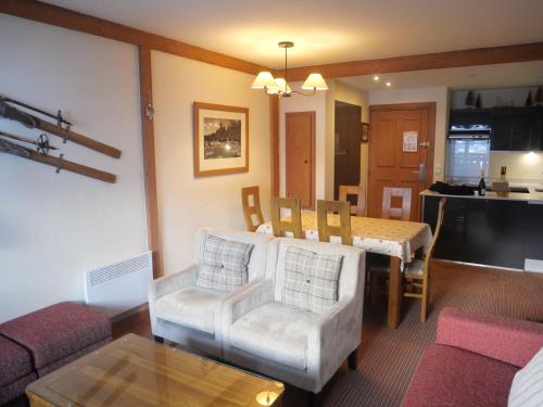 un salon avec un canapé et une salle à manger dans l'établissement Stunning 3 bed duplex in the heart of Arc 1950 village - sleeps 8, à Bourg-Saint-Maurice