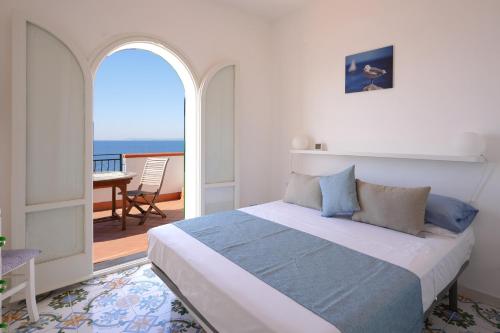 a bedroom with a bed with a view of the ocean at House Dream on the sea in Massa Lubrense