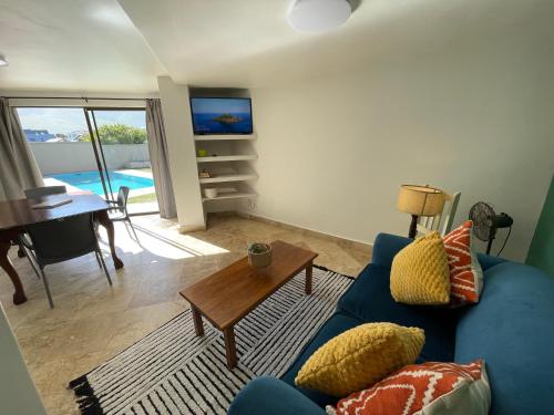 a living room with a blue couch and a table at Bird's View Guest Accommodation in Hermanus