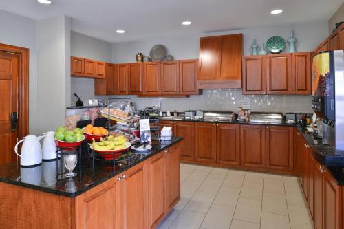 a kitchen with wooden cabinets and fruit bowls on the counter at Residence Inn Columbia Northeast/Fort Jackson Area in Columbia