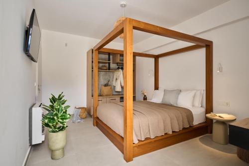 a bedroom with a wooden canopy bed with white pillows at Kyamon Luxury Villa - Peaceful Escape with Heated Pool near Chania! in Chania Town
