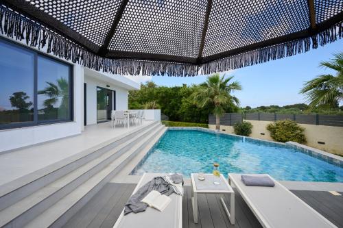 a swimming pool in a villa with a house at Kyamon Luxury Villa - Peaceful Escape with Heated Pool near Chania! in Chania Town