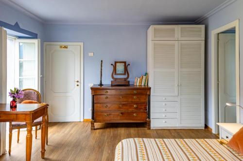a bedroom with a bed and a dresser and a mirror at Casa della Musica in Verbania