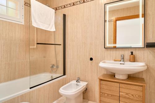 a bathroom with a sink and a toilet and a mirror at Balcón del Mar in La Herradura