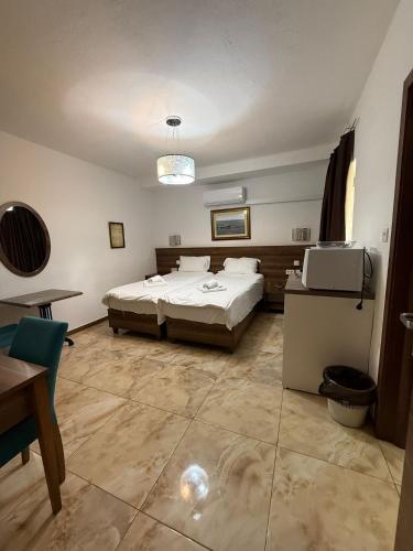 a large bedroom with a bed and a table and a chair at Slimiza Suites in Sliema