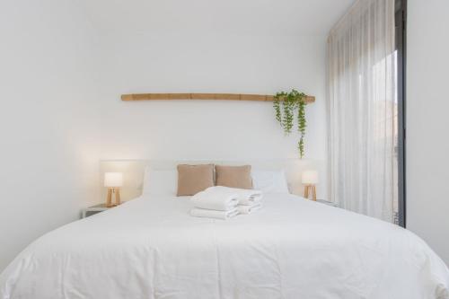 a white bedroom with a large white bed with towels on it at Milenial Immo VT2-1 Figueres Dali Museum and Rambla in Figueres