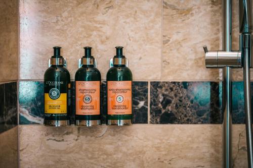 three bottles of wine sitting on a shelf in a bathroom at BALTAZÁR Boutique Hotel in Budapest