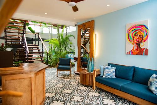 a living room with a blue couch and a staircase at Central Hotel Boutique in Las Galeras