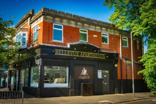 a brick building with a sign for a restaurant at OYO Bellevue Apartments Middlesborough in Middlesbrough