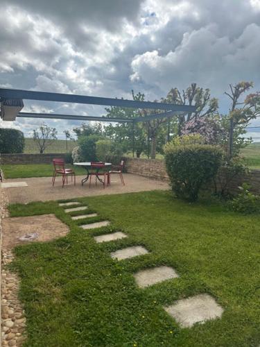 a garden with a table and a picnic table in the grass at Hôtel-Restaurant le Château de Besseuil, Mâcon Nord - Teritoria in Clessé
