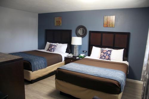 2 Betten in einem Hotelzimmer mit blauen Wänden in der Unterkunft South T Motel in Spencer