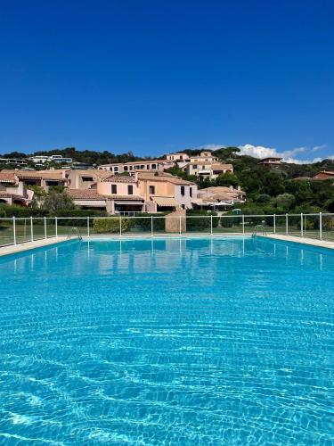 un grand bassin d'eau bleue avec des bâtiments en arrière-plan dans l'établissement Les Couchants - Villa 6 pers - Splendide vue mer, à Grosseto-Prugna