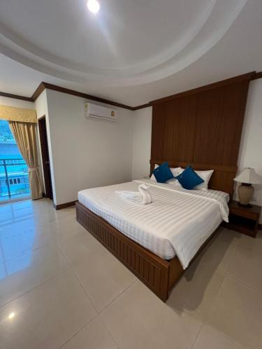 a bedroom with a large bed with blue pillows at SK Residence And Restaurant Patong in Patong Beach