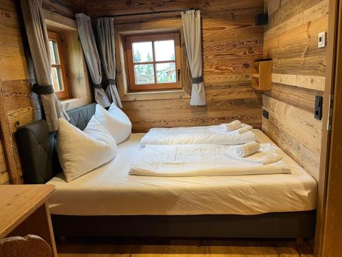 Un dormitorio con una cama en una cabaña de troncos en Chalet Hüttenzauber, en Saalbach Hinterglemm