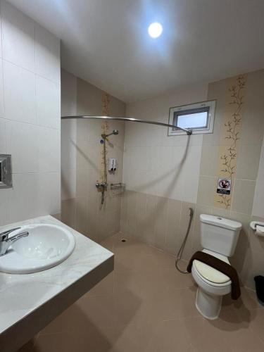 a bathroom with a toilet and a sink at SK Residence And Restaurant Patong in Patong Beach