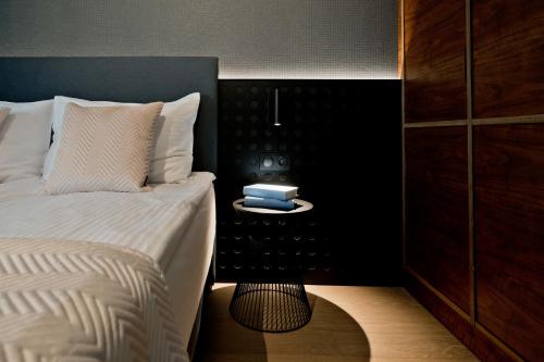 a bedroom with a bed and a side table with a alarm clock at Apartamenty Wydma & Las BlueApart in Jastarnia