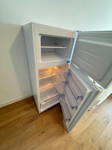 un réfrigérateur vide avec une porte ouverte dans une pièce dans l'établissement logement 5 tout confort gare centre, à Poitiers
