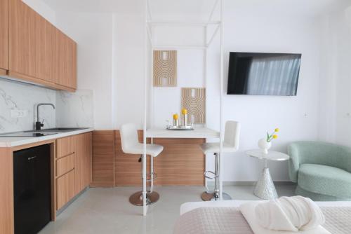 a small kitchen with a sink and a table in a room at Stavros Beachfront Suites in Nea Kydonia