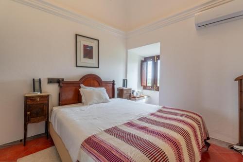 a bedroom with a large bed with a striped blanket at Convento da Orada - Monsaraz in Monsaraz