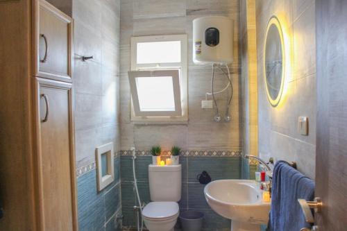 a bathroom with a toilet and a sink at Coral Hills 2nd Row Chalet with Panoramic Sea View in Alexandria