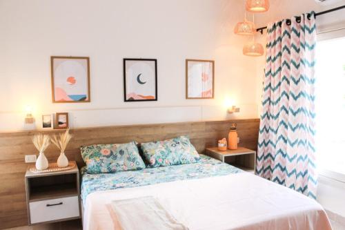 a bedroom with a bed and some pictures on the wall at Coral Hills 2nd Row Chalet with Panoramic Sea View in Alexandria