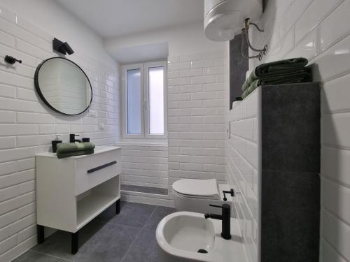 a white bathroom with a toilet and a mirror at Vacation home Bujas in Pag