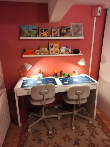 un bureau jouet avec deux chaises dans une pièce dans l'établissement La Villa Rouge, à Saint-Martin-la-Rivière