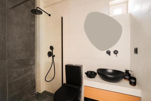 a bathroom with a black sink and a shower at Stavros Beachfront Suites in Nea Kydonia