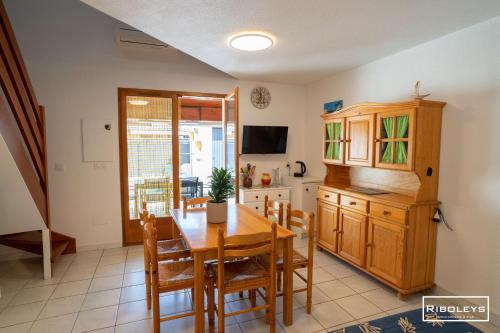 une cuisine et une salle à manger avec une table et des chaises dans l'établissement Charmante maison climatisée à 500m de la plage, à Vias