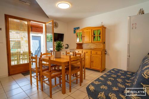 une cuisine et une salle à manger avec une table et des chaises dans l'établissement Charmante maison climatisée à 500m de la plage, à Vias