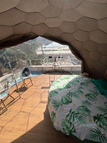 a room with a bed and a camera on a roof at Bubble World Wild Love in Adelfia