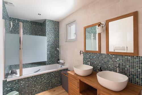 a bathroom with a tub and a sink and a mirror at Villa Ker Jade - vue sur la mer in Lancieux