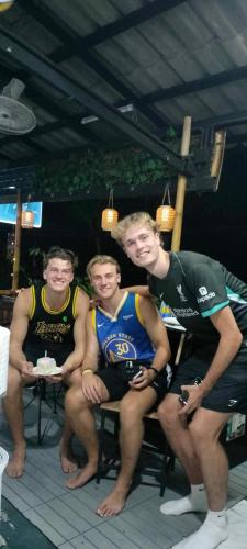 a group of young men sitting on a table at Sweed Dee Hostel in Phi Phi Don