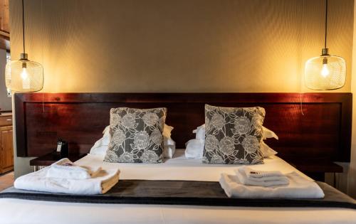 a bedroom with a bed with two towels on it at Elegant Lodge & Conference Center in Pongola