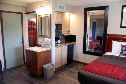 Schlafzimmer mit einem Bett, einem Waschbecken und einem Spiegel in der Unterkunft South T Motel in Spencer