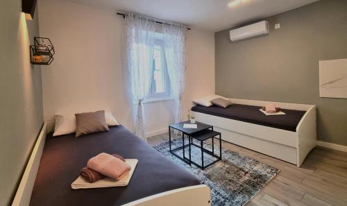 a small room with two beds and a window at Vacation home Bujas in Pag