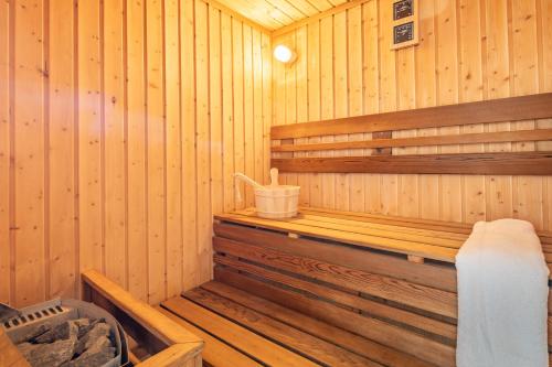 a wooden sauna with a bench in it at BalatonGardens Apartman in Balatonudvari