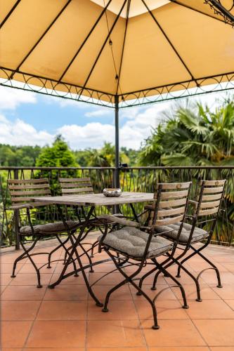 a table and chairs under an umbrella on a patio at Casa della Musica in Verbania