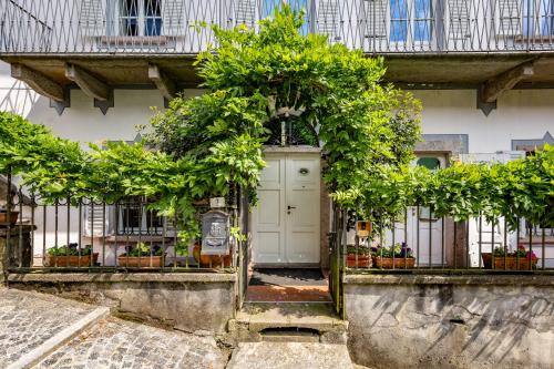a white building with a door with plants at Casa della Musica in Verbania