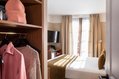 a hotel room with a bed and a window at Hotel Le Colombier in Obernai
