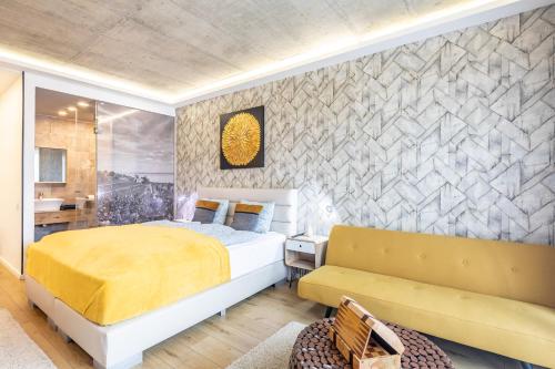 a bedroom with a king sized bed and a couch at BalatonGardens Apartman in Balatonudvari