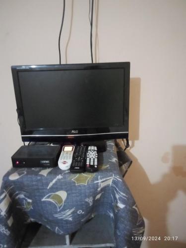 a computer monitor sitting on top of a table with remotes at Hospedaje El Quebracho in Caña de Castilla