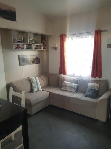 un salon avec un canapé et une fenêtre dans l'établissement Mobilhome sur terrain privé, à La Celle-sous-Gouzon