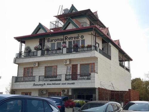 a building with cars parked in front of it at Baromas Retreat in Jawālāpur