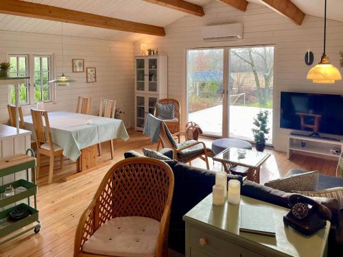 a living room with a table and a dining room at Holiday Home With Views Of Nature In Ertebølle in Farsø