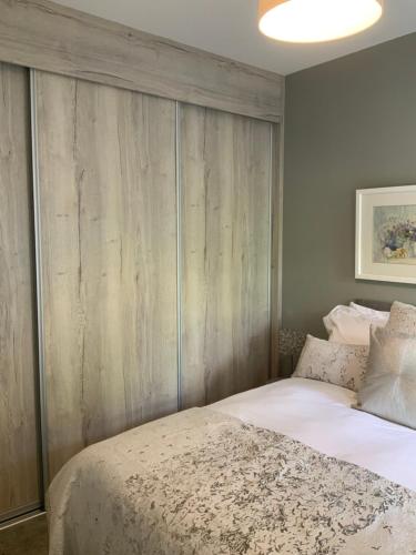 ein Schlafzimmer mit einem Bett mit einem hölzernen Kopfteil in der Unterkunft Village Retreat in Hillsborough