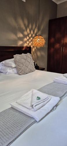 a white towel sitting on top of a bed at Elegant Lodge & Conference Center in Pongola